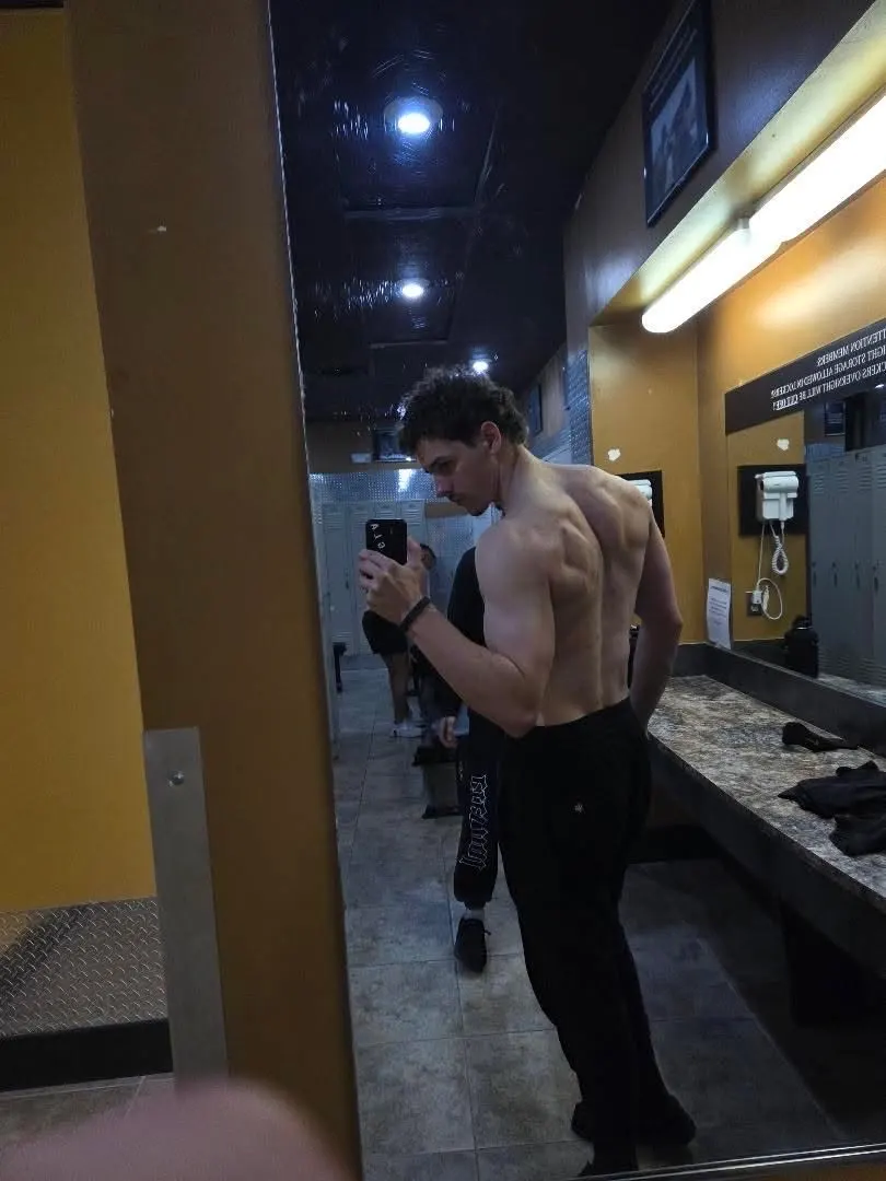 Sam checking his side profile in a locker room mirror